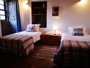 a bedroom with two beds and a table with a lamp at Casa do Pontelhão Serra d'Arga in Arga de Cima