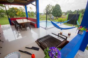 eine Terrasse mit einer Hängematte, einem Tisch und einem Esszimmer in der Unterkunft Guacamayo Azul in Iquitos