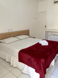 um quarto com uma cama grande com duas toalhas em Pousada Barra Bonita em Barra de São Miguel