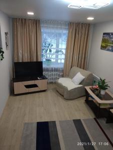 sala de estar con sofá y TV en Apartments on Lenina Street 75, en Novosibirsk