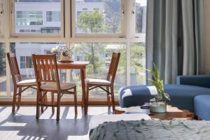 a living room with a table and chairs in front of a window at 朵麗絲森林 in Meishan