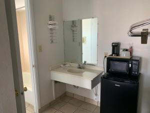 a small bathroom with a sink and a microwave at Economy Inn Motel in Kingman +35 photos