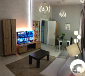 uma sala de estar com um sofá e uma televisão em Inbox Apartments em Bitola