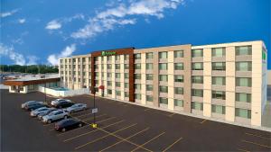 a large building with cars parked in a parking lot at Holiday Inn Chicago Midway Airport S, an IHG hotel in Chicago