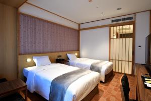 En eller flere senger på et rom på Hotel Gracery Taipei