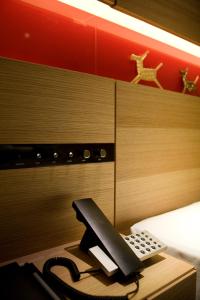 - un téléphone sur un bureau à côté d'un lit dans l'établissement Hotel Metropolitan Akita, à Akita