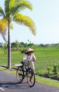 osoba jeżdżąca rowerem po drodze w obiekcie Tamu Seseh w mieście Canggu