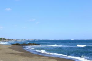 a beach with waves crashing on the shore at Tamu Seseh in Canggu