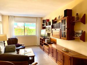 a living room with a couch and a television at Sitges Living Apartment in Sitges