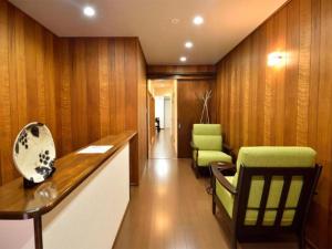 京都市にある香水庵の木製の壁の廊下、緑の椅子が備わる客室です。