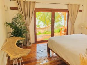 ein Schlafzimmer mit einem Bett und einer Glasschiebetür in der Unterkunft Mangata Boutique Bungalows in Srithanu