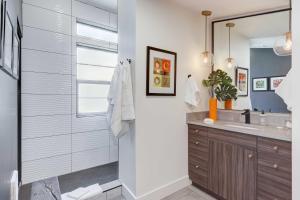 博伊西Stylish and Modern Boise Studio with Foothills Views!的带淋浴、水槽和镜子的浴室 更多16张照片