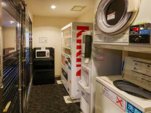 een wasruimte met een wasmachine en een magnetron bij APA Hotel Miyazaki Nobeoka Chuo in Nobeoka