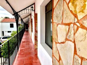 balcón con pared de piedra y ventana en HOTEL LOS ROBLES, en Nuevo Laredo