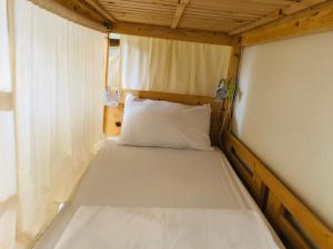 台東市的住宿－1981民宿，一张位于小房间的床,配有白色枕头
