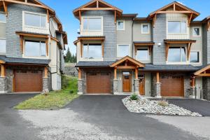a house with a driveway in front of it at Spacious Modern Ski-in Ski-out with Hot Tub Townhouse in Sun Peaks