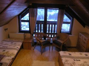 a room with a table and chairs and windows at Woodhouse in Rokytnice nad Jizerou