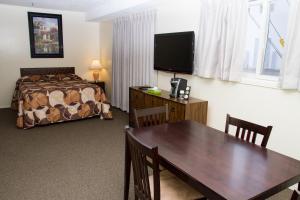 um quarto de hotel com uma mesa de jantar e uma cama em Wheel Inn Motel em Assiniboia