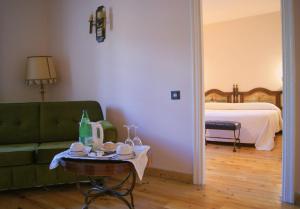 a living room with a green couch and a table at Hotel Temple Pradorrey in Astorga