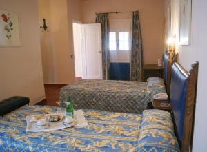 a room with two beds and a table with a tray of food at Hotel Temple Pradorrey in Astorga +11 photos