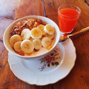 a bowl of cereal and bananas on a plate with a drink at Pian di Rocca Country in Castiglione della Pescaia