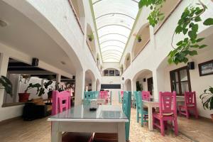 une chambre avec des chaises et des tables colorées dans un bâtiment dans l'établissement Jardines de Luz, à San Cristóbal de Las Casas