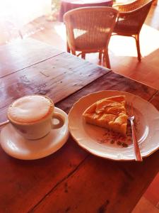 eine Tasse Kaffee und ein Stück Kuchen auf einem Holztisch in der Unterkunft Pian di Rocca Country in Castiglione della Pescaia