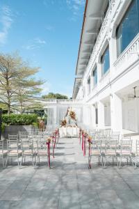 a white table and chairs with a table and flowers at Oasia Resort Sentosa by Far East Hospitality in Singapore