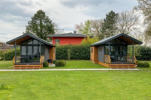 two gazebos in a yard with a red house at Tiny House 1e in Varel