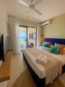 a bedroom with a large bed and a television at Eastern Blue - Sea View Luxury Apartment in Poste Lafayette