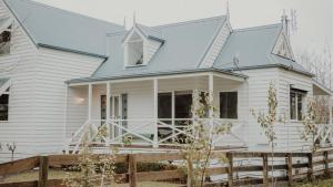 une maison blanche avec un toit bleu dans l'établissement Birch Cottage, à Trentham