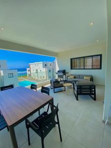 a dining room with a table and chairs and the ocean at Eastern Blue - Sea View Luxury Apartment in Poste Lafayette