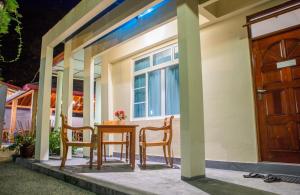 a table and chairs on the porch of a house at Charming Holiday Lodge in Midu