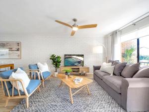 uma sala de estar com um sofá e uma ventoinha de tecto em Catch of the Bay by Experience Jervis Bay em Vincentia