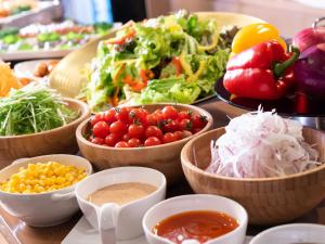 a table topped with bowls of vegetables and dips at HOTEL MYSTAYS Hiroshima Peace Park in Hiroshima