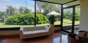 a living room with a white couch and a large window at Residence all'Adige in Verona