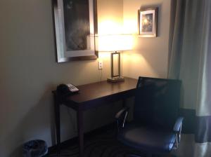 a desk in a hotel room with a lamp and a chair at Executive Inn and Suites Jefferson in Jefferson