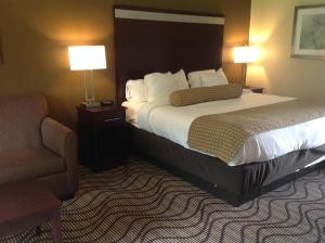 a hotel room with a bed and a chair at Executive Inn and Suites Jefferson in Jefferson