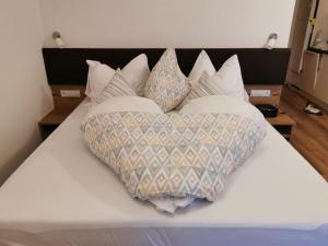 - un lit avec quatre oreillers et un oreiller en forme de cœur dans l'établissement Appartement Grafoner, à Sankt Anton am Arlberg