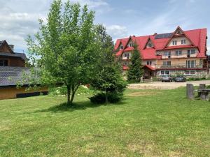 a tree in a yard in front of a building at Na Dolinie in Bukowina Tatrzańska