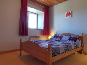 1 dormitorio con 1 cama y una ventana con cortinas rojas en Gîte Les Estables, 3 pièces, 6 personnes - FR-1-582-148, en Les Estables