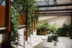 un patio con plantas, mesas y flores en Palazzo della Fontana, en Matera