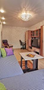 een woonkamer met een tafel en een bank bij Apart-comfort Istanbul in Yaroslavl