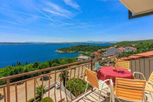 a balcony with a table and chairs and a view of the water at Apartments Rozaria in Dramalj