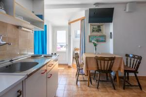 a kitchen with a table and chairs and a kitchen with a sink at Apartments Rozaria in Dramalj