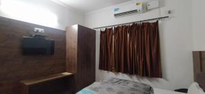 a bedroom with a bed and a television in a room at Hotel Samrat in Dehradun +39 photos