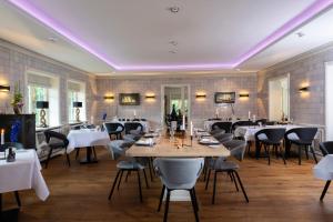 a dining room with tables and chairs and purple lighting at Benen-Diken-Hof in Keitum