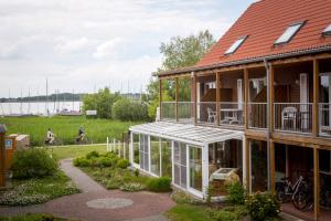 a house with a conservatory with people riding bikes at Ferienzentrum Yachthafen Rechlin in Rechlin