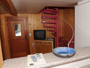uma cozinha com uma escada em espiral vermelha num quarto em wooden chalet in Betten near the Aletsch Arena em Betten