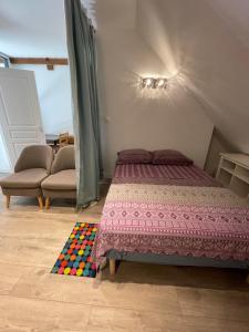 a bedroom with a bed and a colorful rug at Domaine Ravy-La Camélia in Saint-Symphorien-sur-Saône